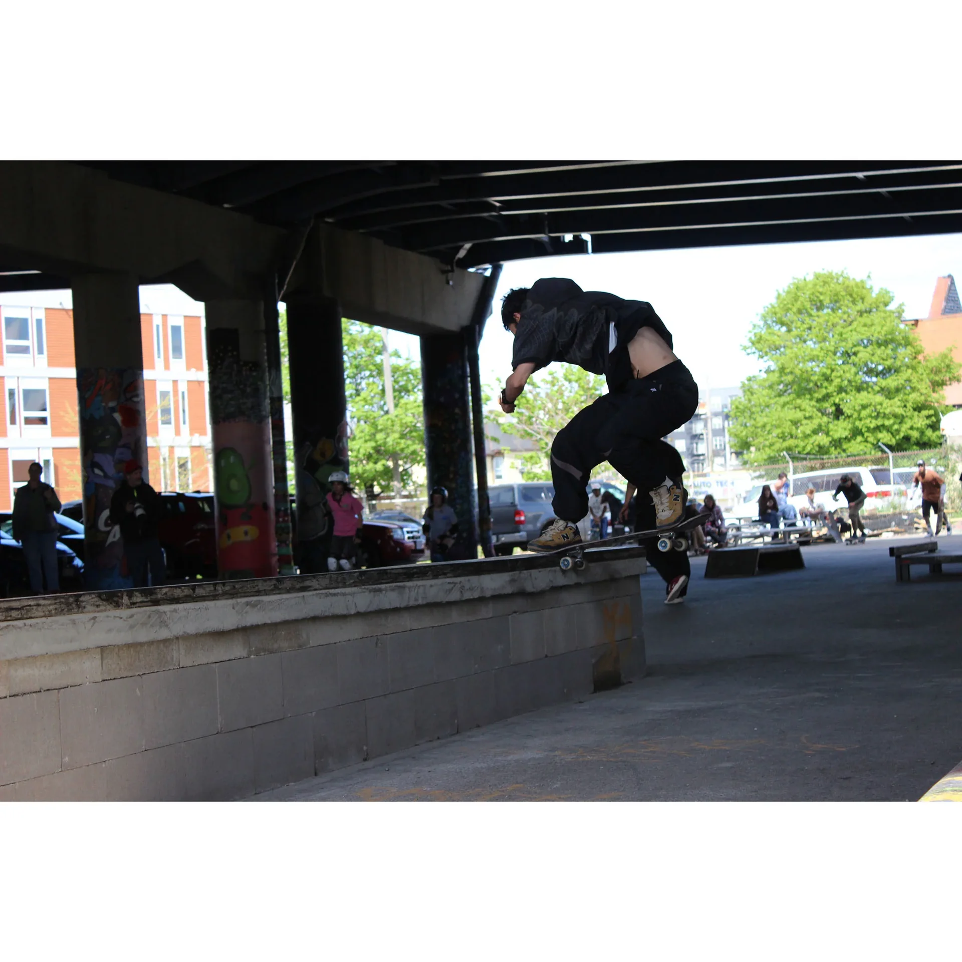 Shot of local skater Sneaky getting a frontside noseslide on the back of the brick bank obstacle.